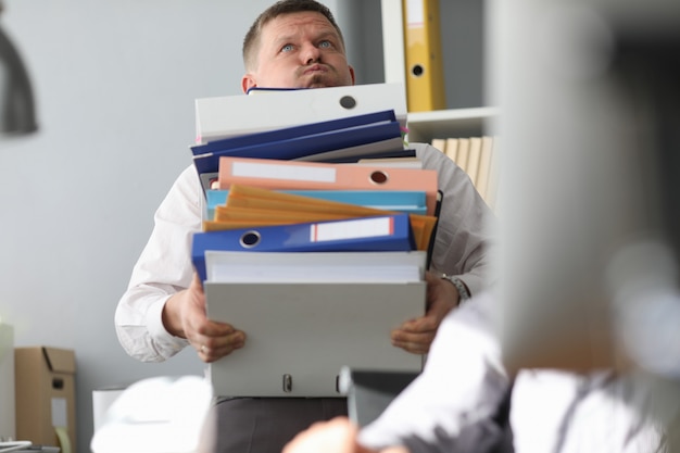 Homme d'affaires porte un tas de dossiers