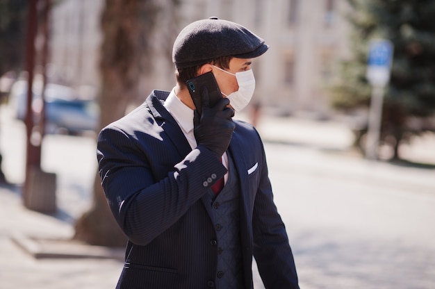 Homme d'affaires porter sur costume et casquette avec masque médical, parler au téléphone. MERS-Cov, Novel coronavirus 2019-nCoV