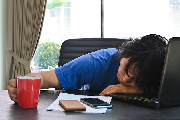 Homme D'affaires Porter Des Vêtements Décontractés Dormir Au Bureau à Domicile Avec Ordinateur Portable Et Tasse De Café Lorsque Vous Travaillez à Domicile .concept Pour Surmené