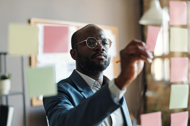 Homme d'affaires prenant des notes sur des notes autocollantes