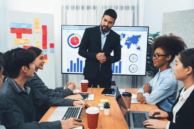 Homme d'affaires présentant l'affichage du tableau de bord d'analyse de données sur l'écran du téléviseur lors d'une réunion moderne pour la stratégie marketing Présentation d'entreprise avec un groupe de gens d'affaires dans la salle de conférence Concord