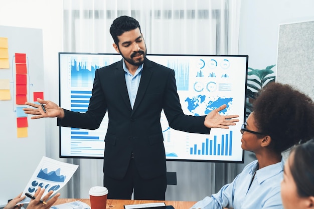 Homme d'affaires présentant l'affichage du tableau de bord d'analyse de données sur l'écran du téléviseur lors d'une réunion moderne pour la stratégie marketing Présentation d'entreprise avec un groupe de gens d'affaires dans la salle de conférence Concord
