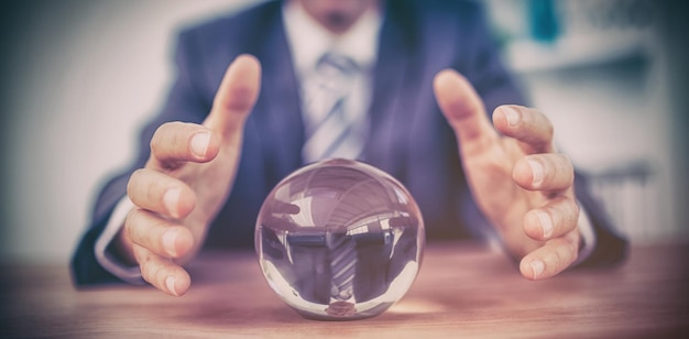 Homme d'affaires prévoyant une boule de cristal au bureau