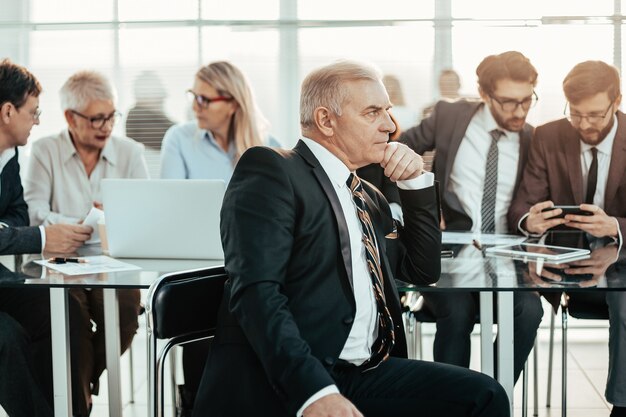 Homme d'affaires prospère assis devant un bureau