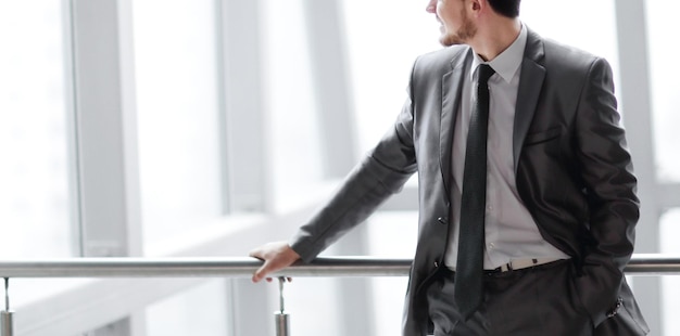 Homme d'affaires prospère debout dans le hall d'un bureau moderne