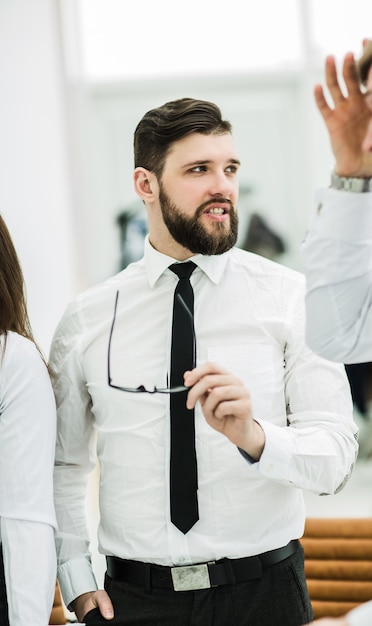 homme d & # 39; affaires prospère avec des lunettes à la main sur le lieu de travail au bureau