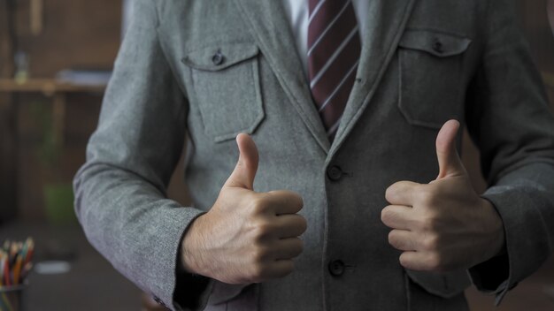 Homme D'affaires Prospère Montre Un Geste Du Pouce Levé. Le Leader Masculin Exprime Des émotions Positives Afin De Remonter Le Moral De Son équipe. Concept D'entreprise Réussi