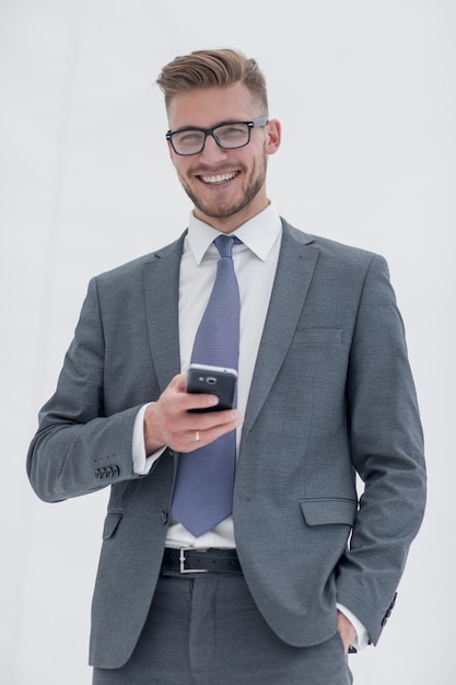 Homme d'affaires prospère avec un smartphoneisolated on white