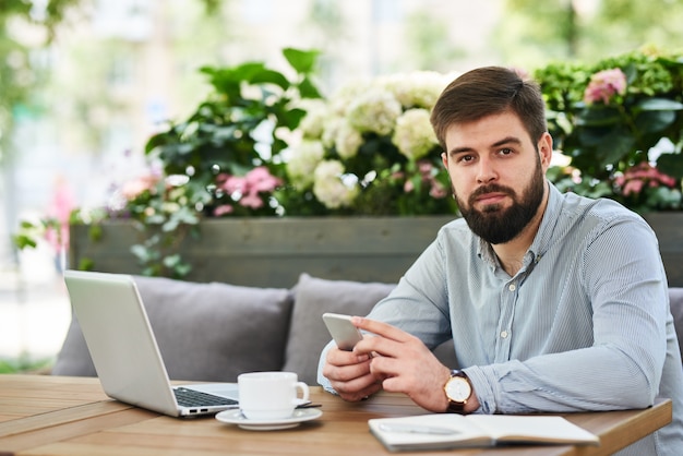 Homme d'affaires prospère travaillant au café