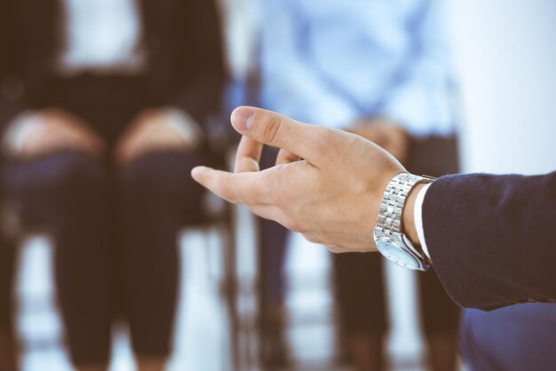 Un homme d'affaires qui fait une présentation à un groupe de personnes en poste. Un conférencier qui donne un séminaire à ses collègues ou une formation en affaires. Travail d'équipe et concepts de coaching en affaires.