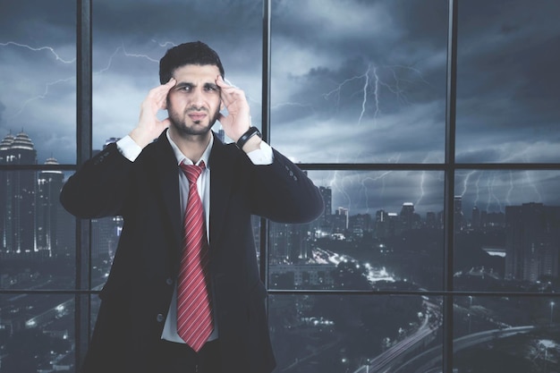 Photo un homme d'affaires qui a mal à la tête au bureau.