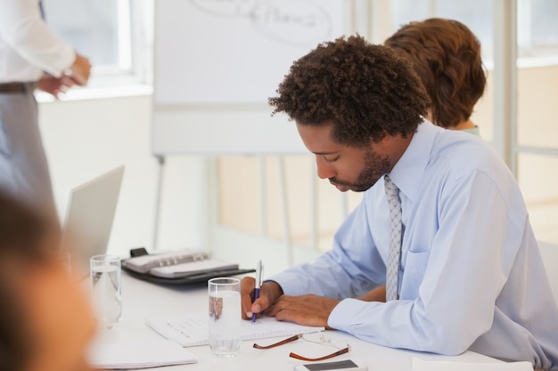 Photo homme d'affaires, rédaction de notes en réunion au bureau