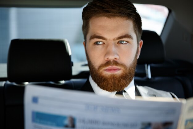 Homme d'affaires réfléchi avec journal