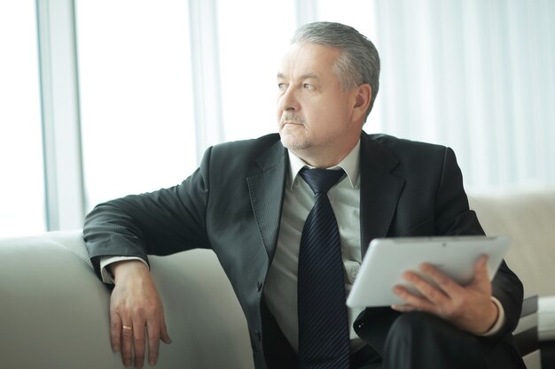 Homme d'affaires réfléchi avec tablette numérique.