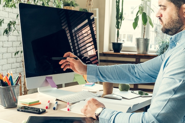 Photo homme d'affaires regardant un écran d'ordinateur pendant la journée de travail au bureau