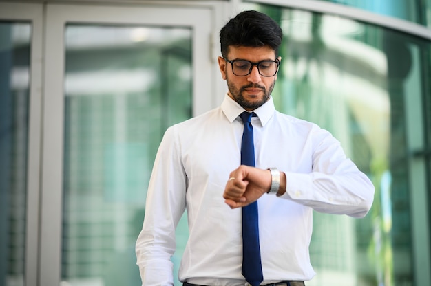 Homme d'affaires regardant le temps dans une ville moderne