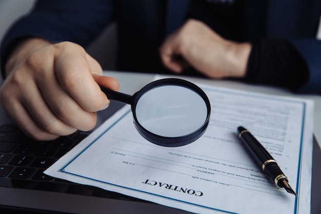 Homme D'affaires Regardant à Travers La Loupe D'un Contrat.