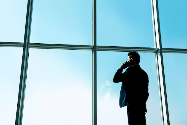 Homme d'affaires regarde par une fenêtre panoramique.