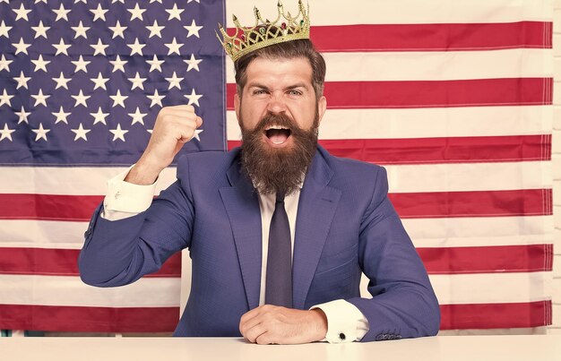 Photo un homme d'affaires réputé, un bel homme assis à son bureau, un drapeau américain, une réputation et un concept de gloire.