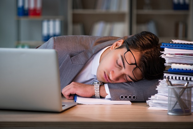 Homme d'affaires restant au bureau pendant de longues heures