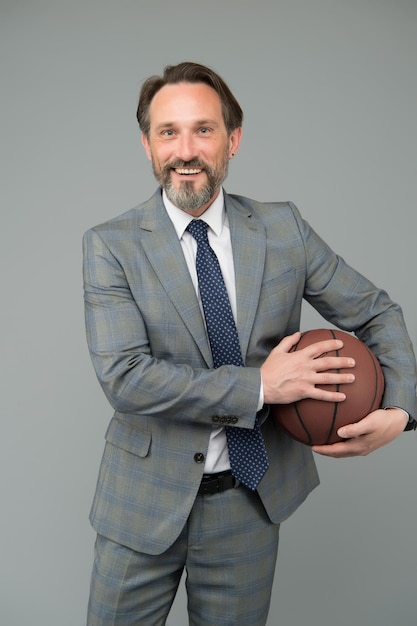 Homme d'affaires se réchauffer avec le basket-ball au bureau, concept de carrière sportive.