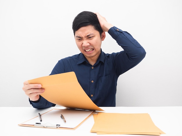 L'homme d'affaires se sentant choqué par l'enveloppe du document dans la main, touche son émotion de tension de la tête