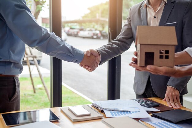 Photo homme d'affaires se serrant la main lors d'une réunion au bureau signature du contrat de vente immobilière entre l'acheteur et le courtier