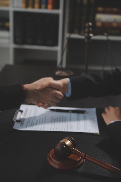Photo homme d'affaires se serrant la main pour sceller un accord avec ses avocats partenaires ou avocats discutant d'un accord contractuel