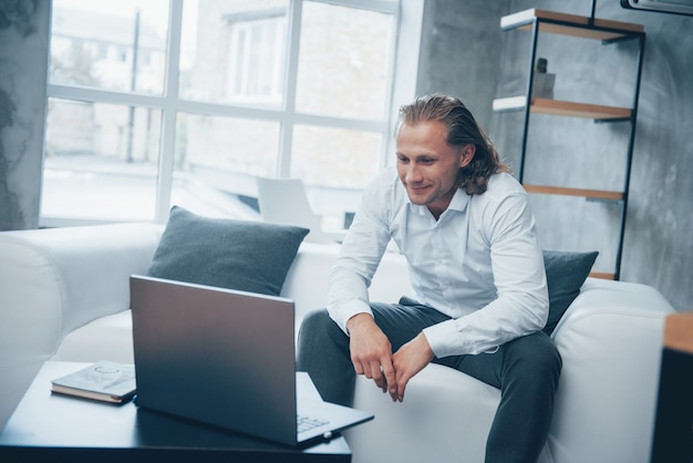 Homme affaires, séance, devant, ordinateur portable, sourire