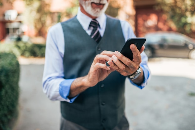 Homme d&#39;affaires senior à l&#39;aide de smartphone. Fermer.