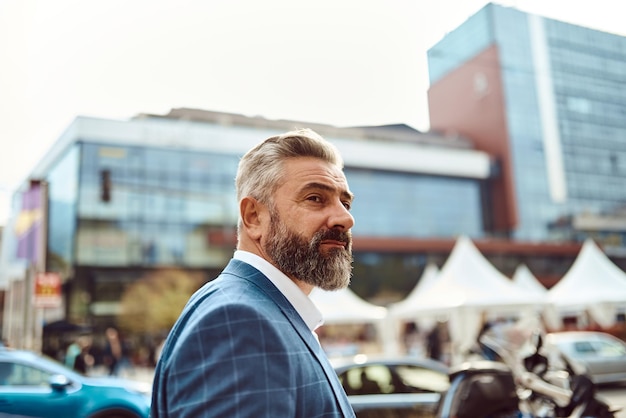 Un homme d'affaires senior en costume se promenant dans la ville après le travail.