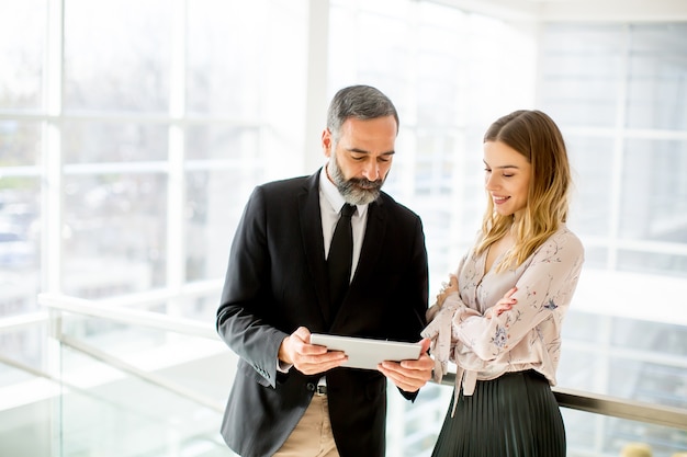 Homme d&#39;affaires senior et jeune femme d&#39;affaires avec tablette au bureau