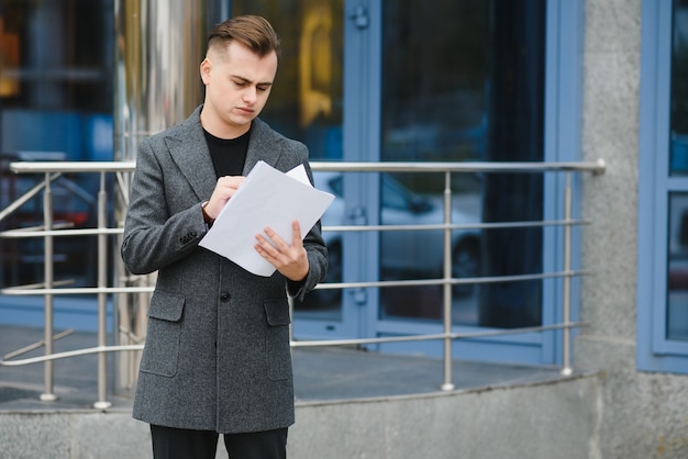 Homme d'affaires sérieux, lecture de documents à la rue