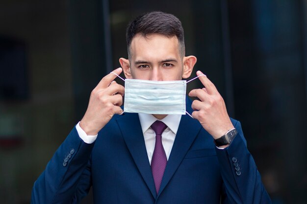 Homme d'affaires sérieux avec masque médical sur son visage