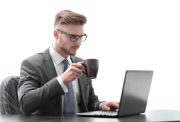 Homme d'affaires sérieux avec une tasse de café assis à son bureau