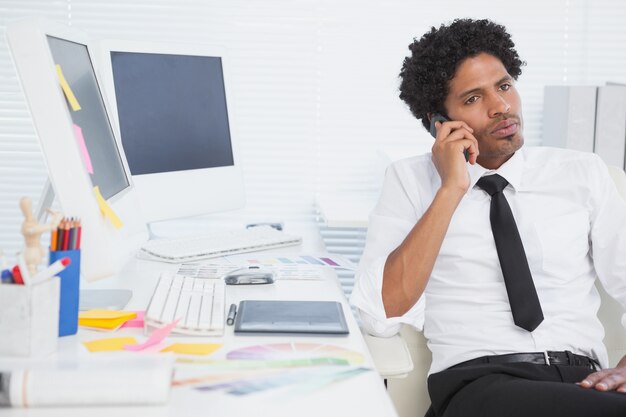 Homme d&#39;affaires sérieux travaillant à son bureau au téléphone