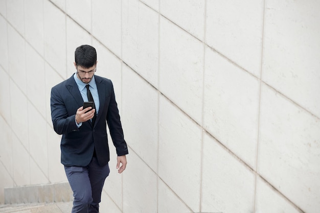 Homme d'affaires sérieux vérifiant le smartphone