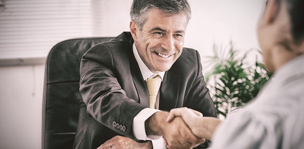 Homme d'affaires serrant la main d'une femme au bureau