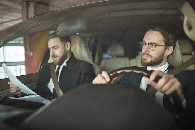 Homme d'affaires et son chauffeur dans la voiture