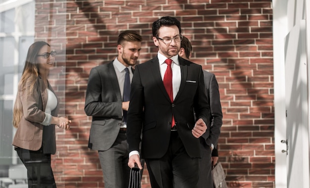 Homme d'affaires et son équipe marchant dans le couloir du bureau