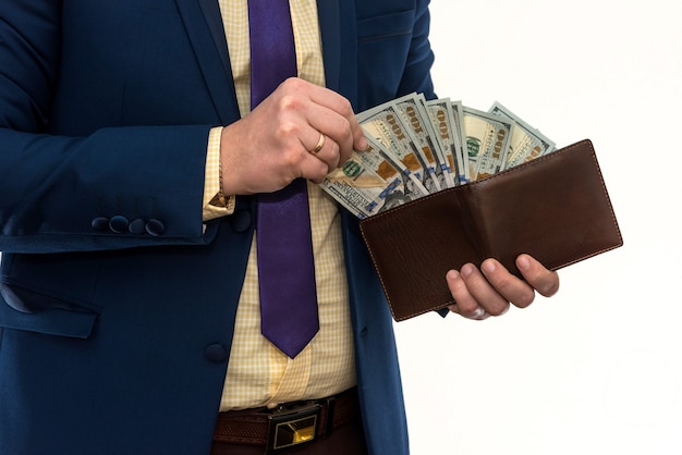 Homme d'affaires sort un billet de 100 dollars de son portefeuille pour faire un achat ou un loyer, isolé sur blanc. L'homme nous tient de l'argent