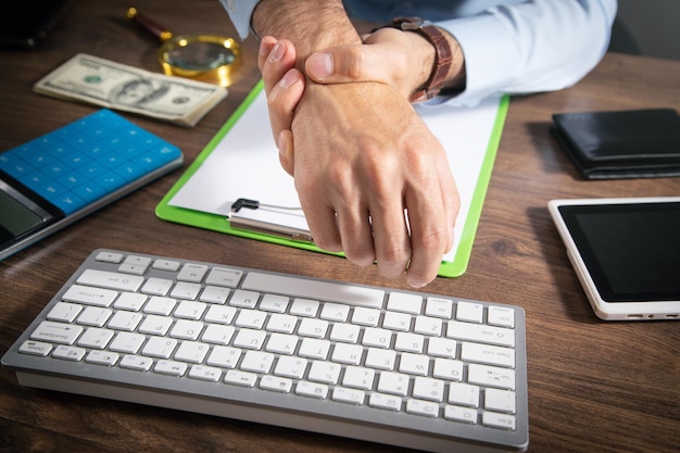 Homme d'affaires souffrant de douleurs à la main au bureau