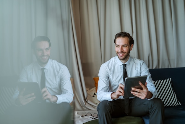 Homme d'affaires souriant à l'aide de tablette.