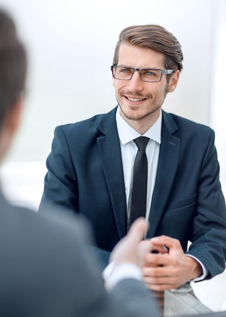 Homme d&#39;affaires souriant, assis à son bureau