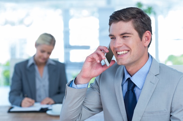 Homme d&#39;affaires souriant ayant un appel téléphonique