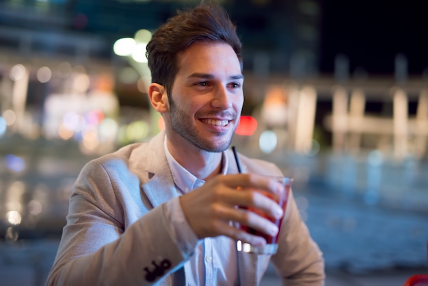 Homme d'affaires souriant, boire un cocktail après le travail