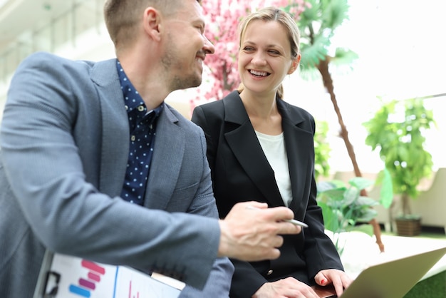 Photo un homme d'affaires souriant discute d'un projet d'entreprise avec une femme d'affaires