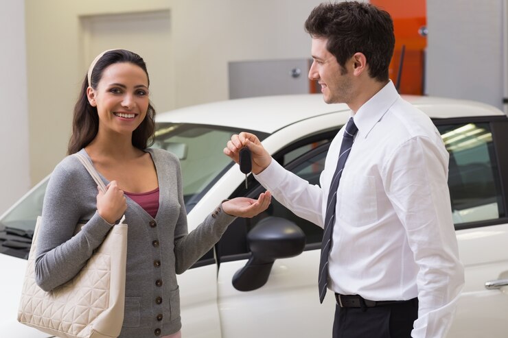 Photo homme d&#39;affaires souriant donnant la clé de la voiture à un client heureux