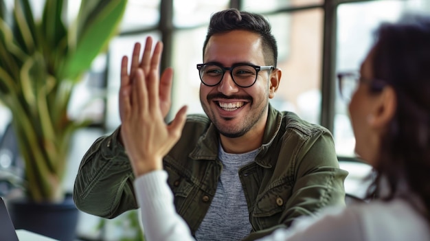 Un homme d'affaires souriant et donnant un highfive à une personne dont le dos est tourné vers la caméra