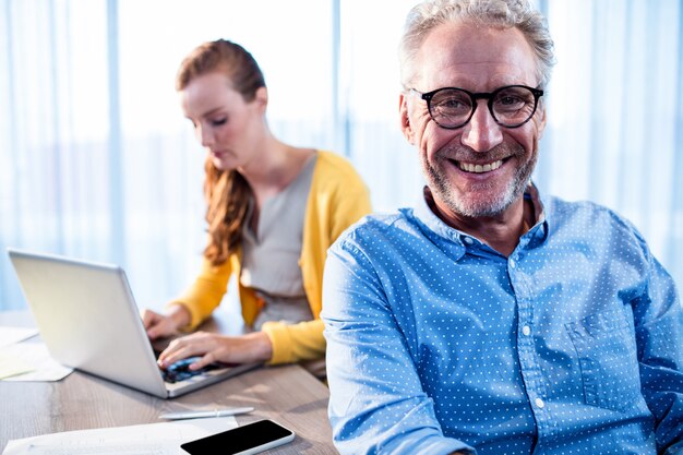 Homme d'affaires souriant et femme d'affaires concentré